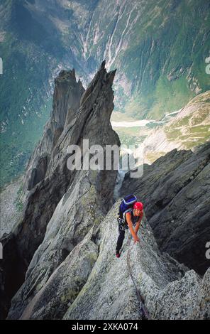 Un scalatore sta salendo una ripida cresta rocciosa in Svizzera. Foto Stock