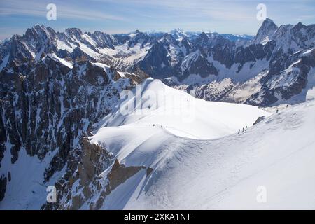 Gli alpinisti stanno scendendo da un'aspra cresta di neve dall'Aiguille du Midi alla Vallee Blanche, un ghiacciaio di alta quota nel massiccio del Monte bianco sopra Chamonix in Francia. Foto Stock