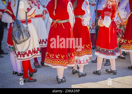 Gruppo di donne irriconoscibili vestite con vivaci costumi tradizionali bulgari con motivi colorati e ricami Foto Stock