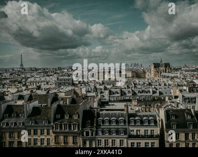 ville de Paris avec vue sur les toits des habitations et la tour Eiffel au loin par temps nuageux Foto Stock