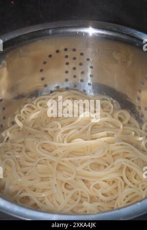 Tagliatelle fresche sgocciolate dopo essere state cotte in un colino Foto Stock