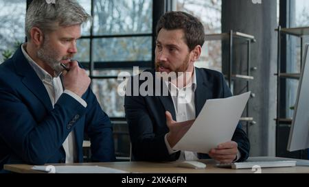 Due insoddisfatti furiosi uomini d'affari caucasici che discutono di un cattivo contratto in ufficio uomini colleghi partner contestano un documento errato non è riuscito Foto Stock