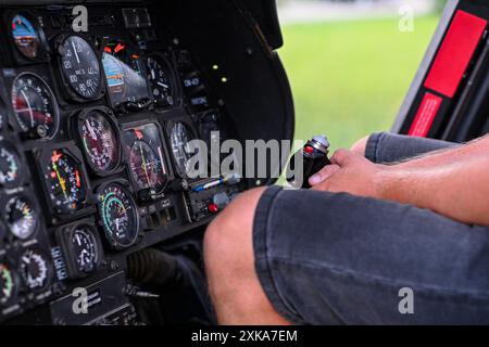 Il pilota si sta preparando al decollo, tenendo i comandi all'interno della cabina di pilotaggio di un elicottero. Foto Stock