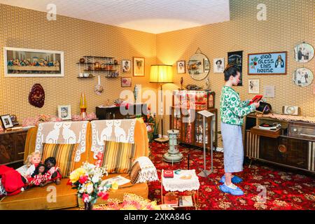 Londra, 22 luglio 2024. Personale del museo nella mostra "A Terraced House nel 1978" di una famiglia dei Caraibi. Il Museum of the Home nella trendy Hoxton apre le sue gallerie "Real Rooms", una nuova mostra permanente che riporta in vita sette nuove sale d'epoca che riflettono le storie interconnesse della comunità multiculturale di East London, dal XX secolo fino al presente e al potenziale futuro. Crediti: Imageplotter/Alamy Live News Foto Stock