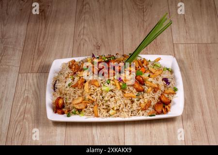 Primo piano di riso fritto con verdure all'aglio bruciato in un piatto di ceramica bianca. Foto Stock