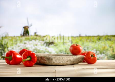 Stativo vuoto con peperoni rossi e verdure di pomodoro su un tavolo in legno con spazio per l'esposizione di prodotti e oggetti da montaggio. Area verde. Foto Stock