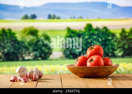 Stativo vuoto con peperoni rossi e verdure di pomodoro su un tavolo in legno con spazio per l'esposizione di prodotti e oggetti da montaggio. Area verde. Foto Stock