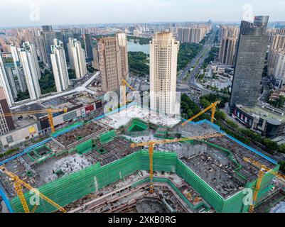 HUAI'AN, CINA - 22 LUGLIO 2024 - i lavoratori stanno lavorando a temperature elevate nel cantiere di un progetto immobiliare in costruzione in Q Foto Stock