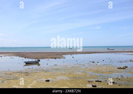 Diverse piccole barche da pesca locali sono ormeggiate sulla costa secca di Samae San, che si trova nella provincia di Chonburi in Thailandia. Foto Stock