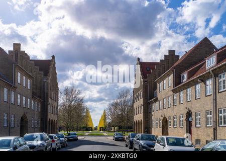Numerose auto parcheggiate lungo la strada accanto alla Grundtvig Church, con un parco in lontananza caratterizzato da alberi a forma di albero di Natale. Copenaghen, Danimarca. Foto Stock