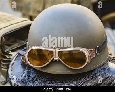 Il vecchio casco da moto con occhiali da sole ad un salone di motori a Malta Foto Stock