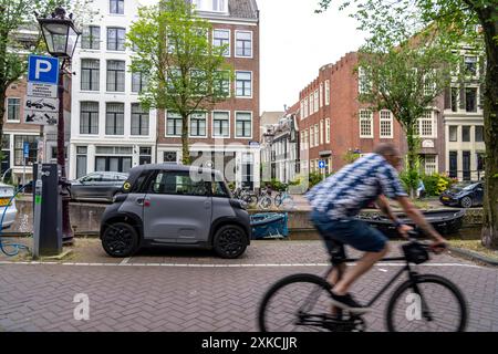 Mini-auto parcheggiata nella città vecchia, sul canale Blauwburgwal, nel centro di Amsterdam, sulla Rocks Electric by Opel, e-car, popolare in città perché richiede Foto Stock