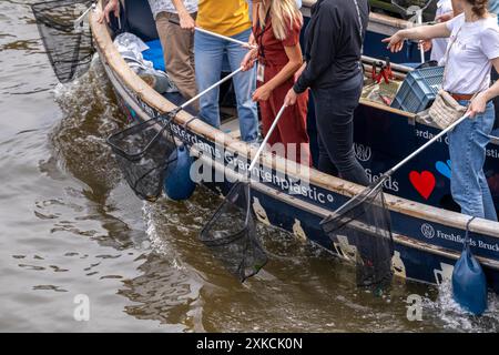 Barca con balena in plastica in un canale di Amsterdam, passeggeri che pescano rifiuti di plastica dai canali, tour attraverso i canali di Amsterdam, raccolta rifiuti A. Foto Stock