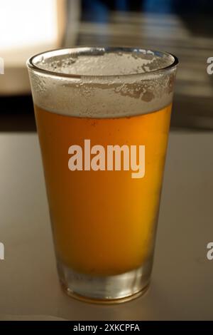 Primo piano di un bicchiere di birra fredda (pale ale) seduta su un tavolo Foto Stock