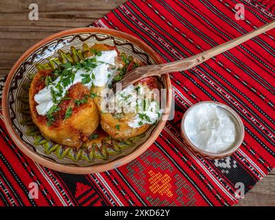 peperoni farciti con carne macinata e serviti con panna acida, cucina balcanica e rumena Foto Stock