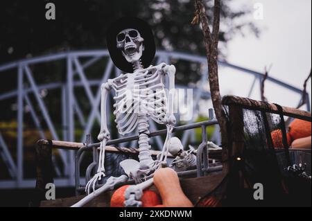 Scheletro umano bianco su carrozza di legno con zucche. Decorazione di Halloween. Foto Stock