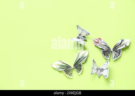 Farfalle Origami fatte di banconote in dollari su sfondo verde Foto Stock