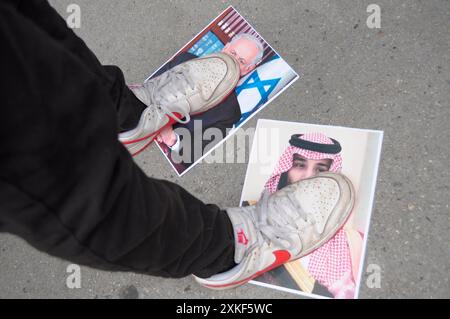 Un manifestante pro-Palestina si avvicina ad una foto del primo ministro israeliano, Benjamin Netanyahu, a sinistra, e ad una foto del principe ereditario e primo ministro dell'Arabia Saudita, Mohammed bin Salman, a destra. I manifestanti pro-palestinesi si sono riuniti a Manhattan, New York, condannando la City University di New York per i suoi collegamenti con le compagnie legate a Israele. Il raduno è iniziato fuori dal CUNY Graduate Center. Da lì, i manifestanti marciarono verso l'edificio degli uffici della CUNY. Il primo ministro israeliano Benjamin Netanyahu visiterà gli Stati Uniti questa settimana ed è previsto che si rivolga al Congresso mercoledì. Sinc Foto Stock