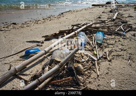 Splendida spiaggia di Sumatra, offuscata dalla realtà dell'inquinamento moderno. Il contrasto di bellezza naturale con le materie plastiche scartate. Ambientale. Foto Stock
