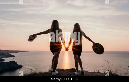 Due silhouette che si tengono per mano al tramonto Foto Stock