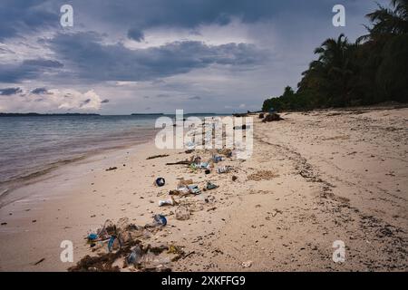 Splendida spiaggia di Sumatra, offuscata dalla realtà dell'inquinamento moderno. Il contrasto di bellezza naturale con le materie plastiche scartate. Ambientale. Foto Stock