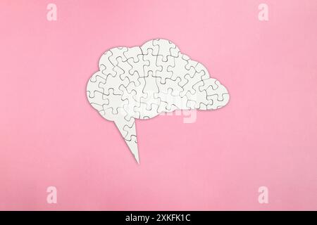 Puzzle puzzle bianco a forma di cervello su sfondo rosa, salute mentale e problemi di memoria Foto Stock