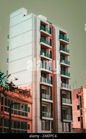 Moderno edificio di appartamenti con più balconi, catturato in un'area urbana. L'architettura presenta linee pulite e un design contemporaneo. Foto Stock