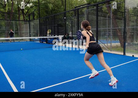 Atleta che gioca a tennis sul campo blu all'aperto Foto Stock