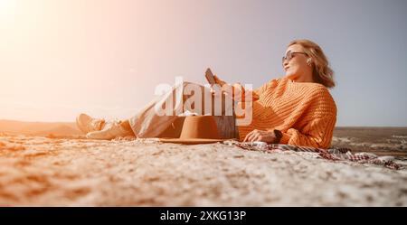 Donna che si rilassa sulla cima di una montagna con vista Foto Stock