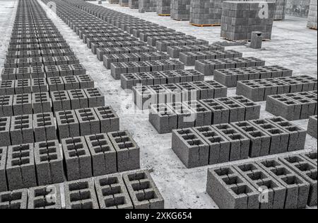 Vista dei blocchi di scorie in calcestruzzo, materiale da costruzione in forma di mattoni grigi. Produzione in fabbrica Foto Stock