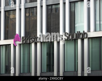 Logo Bristol Myers Squibb, segno della società biofarmaceutica. Facciata di un edificio di uffici con il logotipo del marchio. Un grande datore di lavoro nel mondo. Foto Stock