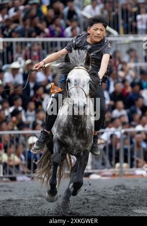 Butuo, la provincia cinese del Sichuan. 22 luglio 2024. Un ragazzo partecipa a una corsa di cavalli durante un festival delle torce nella contea di Butuo, nella provincia del Sichuan, nel sud-ovest della Cina, il 22 luglio 2024. Dal 21 al 23 luglio si è tenuto nella contea di Butuo un tradizionale festival delle torce del gruppo etnico Yi. Le persone hanno partecipato a vari eventi sportivi popolari come corse di cavalli, combattimenti di pecora, corrida e wrestling durante il festival. Crediti: Jiang Hongjing/Xinhua/Alamy Live News Foto Stock