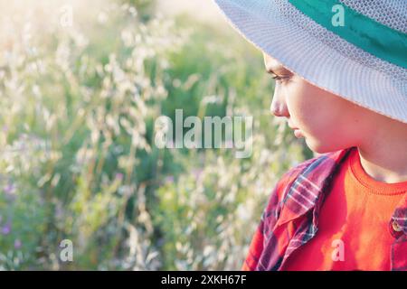 bambino nel campo che osserva la vegetazione Foto Stock