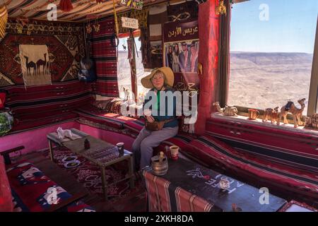 Una donna che beve un caffè turco all'interno della caffetteria beduina Aldi e un chiosco di souvenir al Moujib Panorama vicino a Wadi Mujib, in Giordania Foto Stock