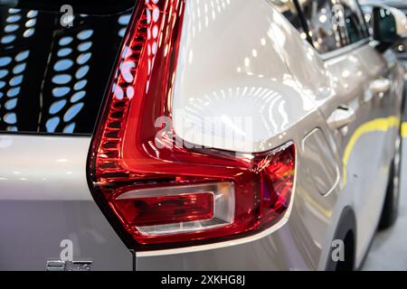 Un alto gruppo di luci posteriori rosse sulla carrozzeria posteriore argentata di un SUV Volvo esposto al chiuso. Foto Stock