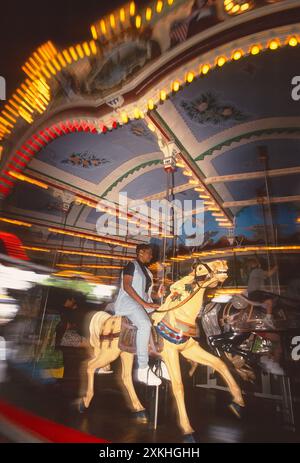 Visitatori che cavalcano un cavallo di legno in movimento su una giostra a "Hershey Park"; Hershey; Pennsylvania; USA Foto Stock