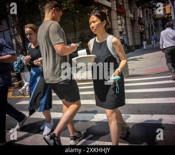 Le persone si affrettano a occuparsi della propria attività durante l'ultima ondata di caldo a Chelsea, New York, martedì 16 luglio 2024. (© Richard B. Levine) Foto Stock