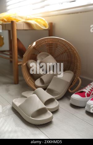 Cestino con pantofole per gli ospiti e scarpe da ginnastica all'ingresso di casa Foto Stock