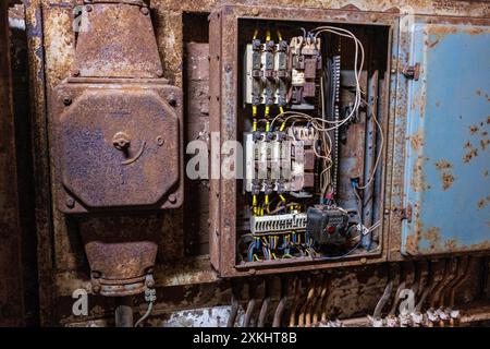 Vecchie spine elettriche e interruttori in un edificio industriale Foto Stock