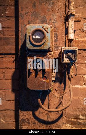 Vecchie spine elettriche e interruttori in un edificio industriale Foto Stock