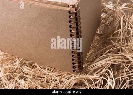 Notebook a spirale collocato su un sfondo di paglia Foto Stock