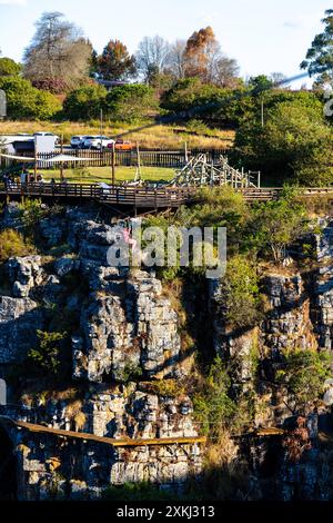 Una ragazza zipline attraversa la Graskop Gorge. Veduta della Gola di Graskop lungo la Panorama Route del Sud Africa nei Monti Drakensberg. Foto Stock