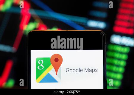 In questa immagine, il sito web del servizio di mappatura web e l'app sviluppata da Google, Google Maps, il logo visualizzato su uno smartphone con un grafico indice di borsa economica sullo sfondo. Foto Stock