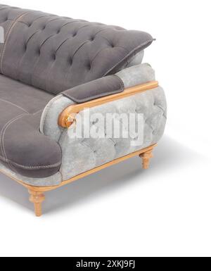 Primo piano dell'elegante braccio grigio del divano con dettagli tufted e dettagli in legno. Foto Stock