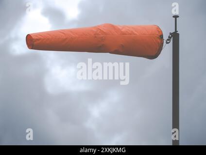 Un Bright Orange Wind Sock in un aeroporto in Un giorno di tempesta, con spazio copia Foto Stock