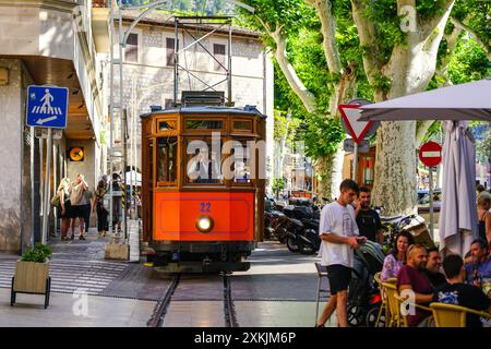 Solera, Spagna - 24 maggio 2024: Un tram d'epoca attraversa la strada del centro storico di Solera con caffè Foto Stock