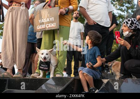 Istanbul, Turchia. 23 luglio 2024. Gli attivisti di destra animale hanno organizzato una manifestazione a Istanbul per protestare contro un disegno di legge redatto dal governo AKP del presidente Recep Tayyip Erdogan che mira a togliere i cani randagi dalle strade. I manifestanti temono che la legge comporti l'abbattimento di massa dei cani di strada, o l'eutanasia. Le persone e il cane portano segni con le parole “ritirare la legge”. Crediti: Ingrid Woudwijk/Alamy Live News Foto Stock