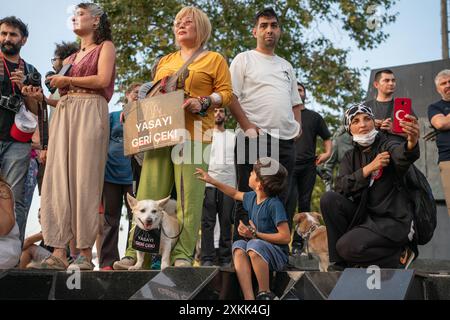 Istanbul, Turchia. 23 luglio 2024. Gli attivisti di destra animale hanno organizzato una manifestazione a Istanbul per protestare contro un disegno di legge redatto dal governo AKP del presidente Recep Tayyip Erdogan che mira a togliere i cani randagi dalle strade. I manifestanti temono che la legge comporti l'abbattimento di massa dei cani di strada, o l'eutanasia. Le persone e il cane portano segni con le parole “ritirare la legge”. Crediti: Ingrid Woudwijk/Alamy Live News Foto Stock