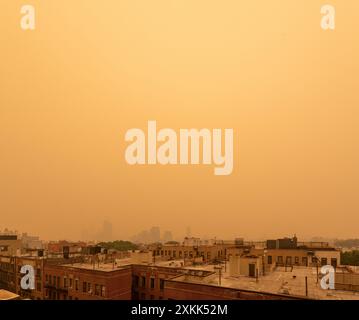 Il fumo proveniente dagli incendi canadesi trasforma il cielo in arancione e blocca la visibilità guardando a nord da un tetto a Brooklyn, New York, Stati Uniti. Foto Stock