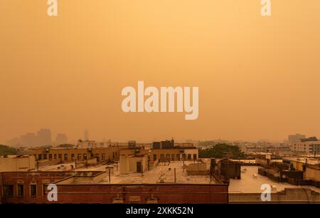 Il fumo proveniente dagli incendi canadesi trasforma il cielo in arancione e blocca la visibilità guardando verso nord-ovest da un tetto a Brooklyn, New York, Stati Uniti. Foto Stock